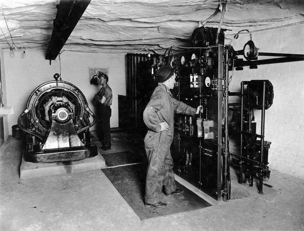 Workers in sub-station no. 2. The workers are operating what appears to be an electric generator. Benham was a "company town" created by International Harvester for the workers of the Wisconsin Steel Company. Wisconsin Steel was a subsidiary of International Harvester and operated coal mines at Benham.