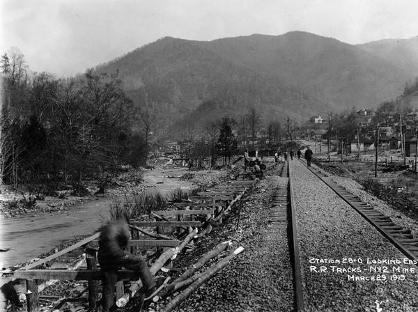 Men building a dock along railroad tracks. The tracks run along a stream or small river. Benham was a "company town" created by International Harvester for the workers employed in the mines of its subsidiary, the Wisconsin Steel Company.