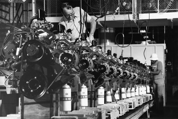 Two factory workers assemble motor truck engines at International Harvester's Indianapolis Motor Truck Engine Works.