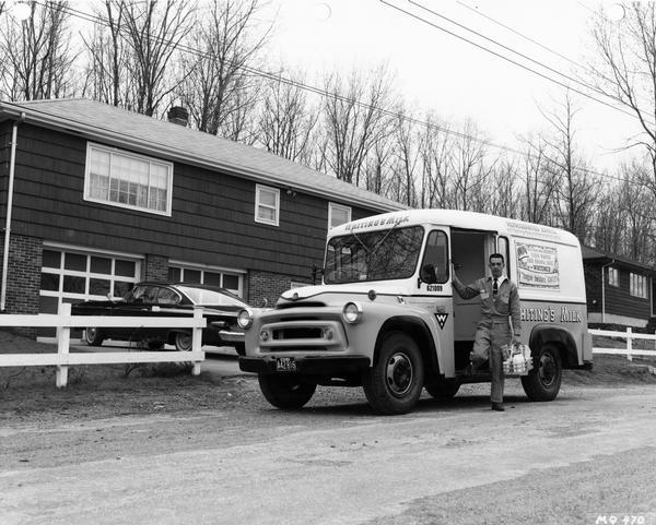 Milkman making a delivery from an International A-140 Metro milk truck. The truck was owned by Whiting's Milk.