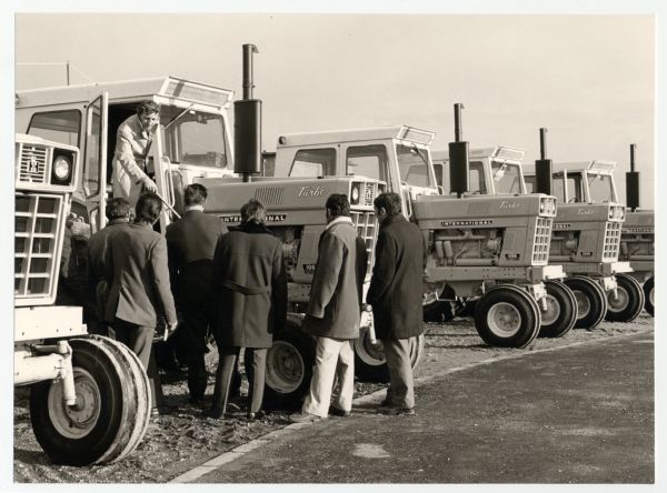 Men looking at International 1066 turbo tractors at the Babolna State Farm in Hungary.