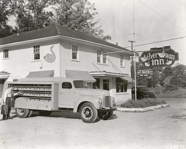 Man delivering beverages to the Silver Swan Inn with an International K-5 truck. The truck was equipped with a 161 x 76 bottle body. Photograph was taken for International Harvester by Howard Weber.