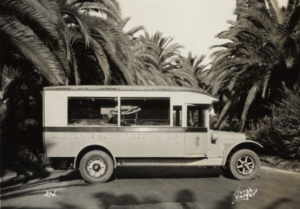 Right side profile view of an International truck with the words: "California Anti-Vivisection Car" on the side. A cat and two dogs can be seen through the side windows. The animals appear to be dead, and have been posed as though they are part of experiments.