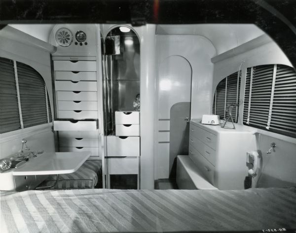 The bedroom of an International "Jungle Yacht," equipped with a bed, telephone, dresser, extra clothing storage, and windows. The "Jungle Yachts" were specially produced by International Harvester for one of the Commander Attilio Gatti's expeditions to the African Congo.