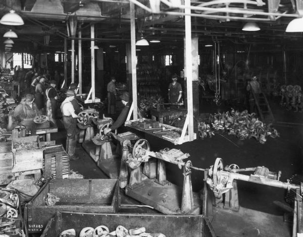 Workers on an assembly line producing mowers at an International Harvester factory - possibly the McCormick Works in Chicago.