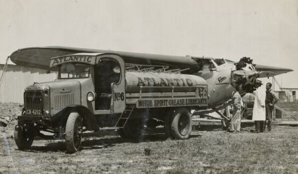 An International truck operated by Atlantic Spirit Grease Lubricants services an airplane while three men wait near the propeller in Port Elizabeth, South Africa.

