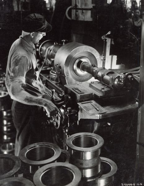 Internal Grinding of Tractor Roller Shell Factory worker operates a machine that grinds the inside of a TracTractor (crawler tractor) track roller shell at Milwaukee Works. Photograph taken by Don Jones.
