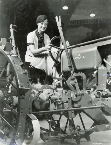 Lillian Anderson of Racine, Wisconsin, Queen of the "A Century of Progress" world's fair, sitting behind the wheel of a Farmall F-12 tractor in the International Harvester exhibit.