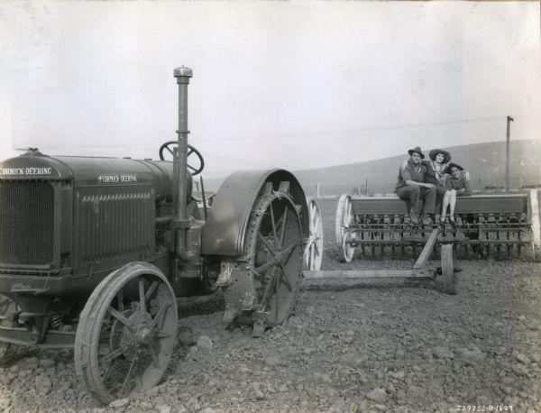 Three actors posing with a McCormick-Deering tractor and grain drill on the set of the Fox Film production "Our Daily Bread".