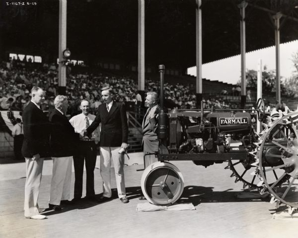 Presentation of a Farmall F-12 tractor to Robert Parmele, the 4-H Farm Accounting contest winner at the Mississippi Valley Fair Grounds. Left to right: S.A. Smith, an International Harvester Corporation branch manager of Davenport; Frank Reed, assistant state 4-H club leader; Francis Johnson, President of Iowa Farm Bureau Federation, Robert Parmele, and G.L. Noble, National Director of the Boys and Girls club.
