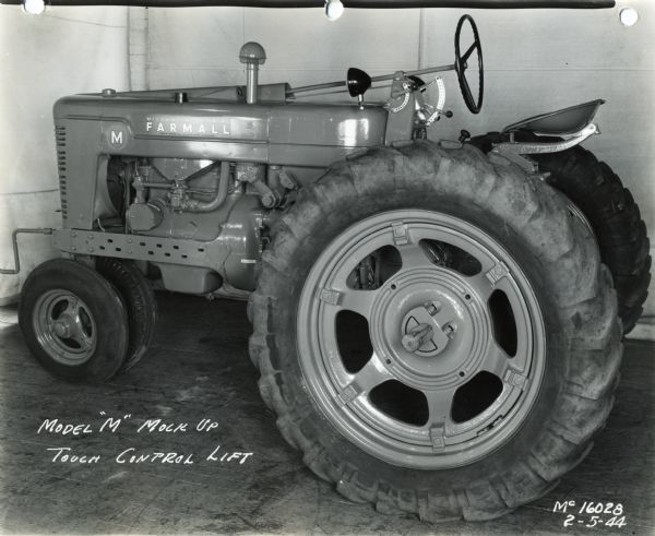 Farmall M Tractor Engineering photograph of a "mock-up" Farmall M tractor. The text on the photograph reads: "Model 'M' Mock Up; Touch Control Lift."