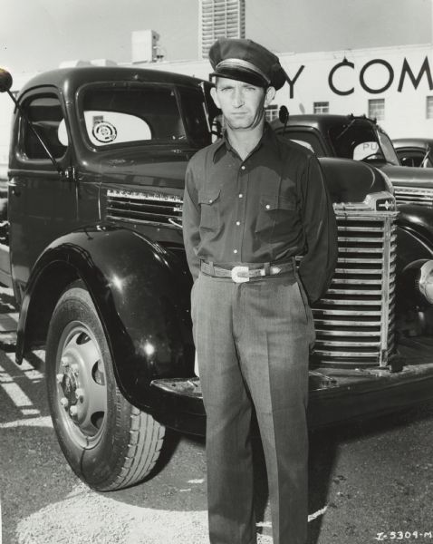 Truck Driver with International Truck International truck driver, identified as "driver of the month," standing in front of his truck.