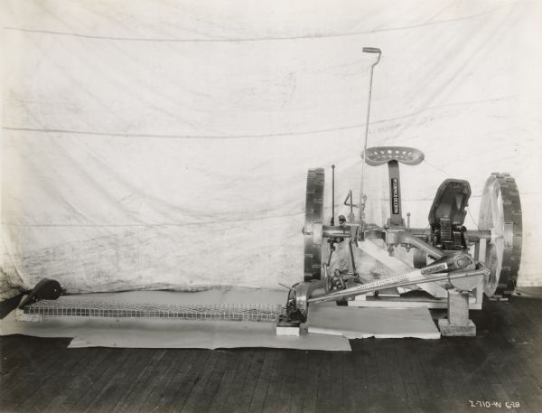 Studio shot of a McCormick-Deering mower showing decals and sickle bar.