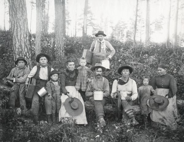 Men, women and children holding boxes and pails in the forest. Original caption reads: "VI Drive to W.S.; Chippewa blueberry pickers." The photograph is part of an album devoted to "Island Lake Camp," a favorite vacation destination of Nettie Fowler McCormick; Cyrus McCormick, Jr.; Harold McCormick; Anita McCormick Blaine and other family members. The camp may have been located in Barron County, between Rice Lake and Ladysmith.