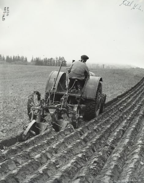 McCormick-Deering 10-20 Pulling Two-Bottom Plow Man driving a McCormick-Deering 10-20 tractor pulling a No. 8-C two-bottom moldboard plow. Original caption reads "Hamilton, Ontario- McCormick Deering 10-20 tractor pulling no.8-c Tractor plow. Hamilton."