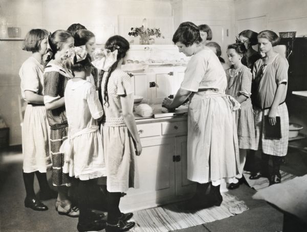 Miss Marilla Zearling demonstrating a bread-making technique to members of the Baker's Dozen Bread Club.