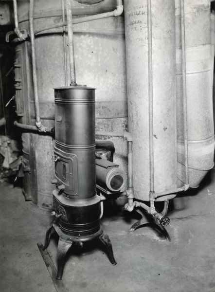 Kerosene hot water heater. Larger tanks are behind the heater.