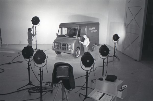 Two men set up a photography shot of an International Metro Mite truck in a studio at International Harvester's Hickory Hill Farm.