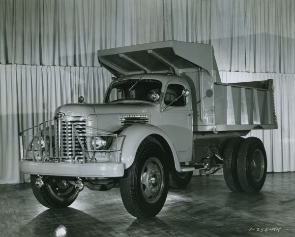 International KB-11 Dump Truck International KB-11 dump truck in a studio or showroom with a curtained backdrop.