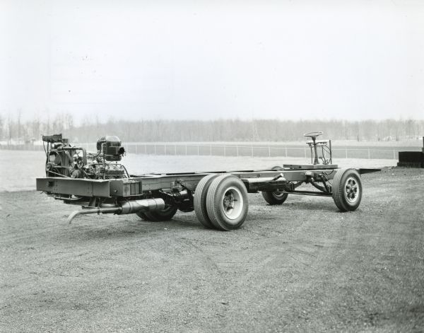 Rear-Engine School Bus Chassis\ Side-view of an International rear-engine school bus chassis parked in a field.