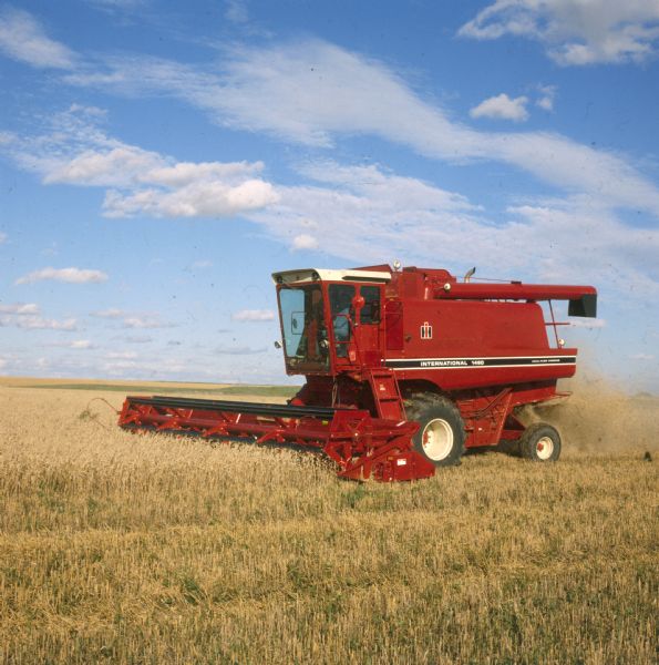 1480 Combine in Field Three-quarter view from left front of man operating a 1480 combine in a field.