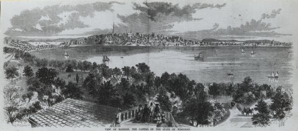 Bird's-eye view of Madison over rooftop and across lake with sailboats and steamers. A group of people are standing on a viewing platform on the roof in the foreground. Caption at bottom reads: "View of Madison, The Capital of the State of Wisconsin."<p>Caption on other versions reads: "Taken from the Water Cure, South Side of Lake Monona."