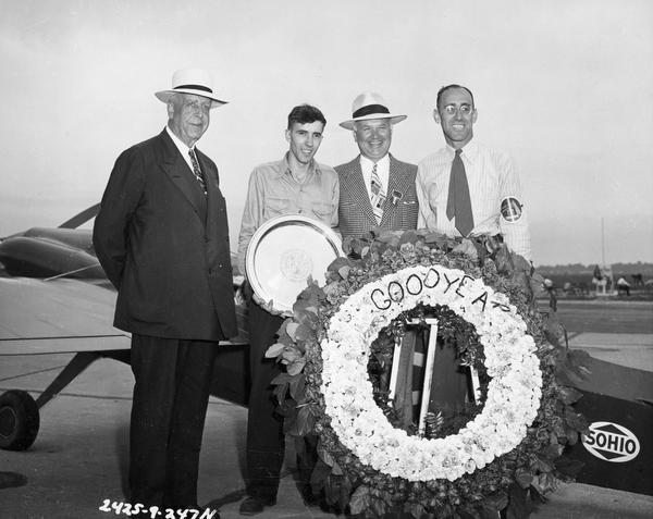The winner of the Goodyear Trophy, Steve Wittman of Oshkosh (on the right) with pilot William Brennand (holding the trophy). With them are Paul Litchfield and E.J. Thomas, chairman and president of Goodyear Tire and Rubber Co. In addition to the Goodyear Trophy, the Wittman team took home a $8,500 prize.