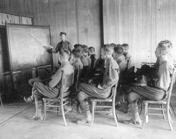 A visiting French officer instructs novice American pilots at Camp Mineola on the conditions that they can expect to find at the front.
