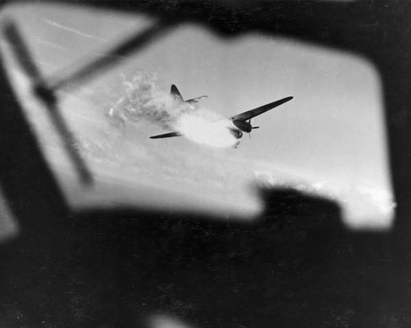 A Japanese bomber going down in flames after having been surprised by a Coronado flying boat of Fleet Air Wing Two.  This photograph, which was shot from the cockpit of the Commando, is part of a scrapbook compiled by Philip F. La Follette, former governor of Wisconsin who served in the Pacific.