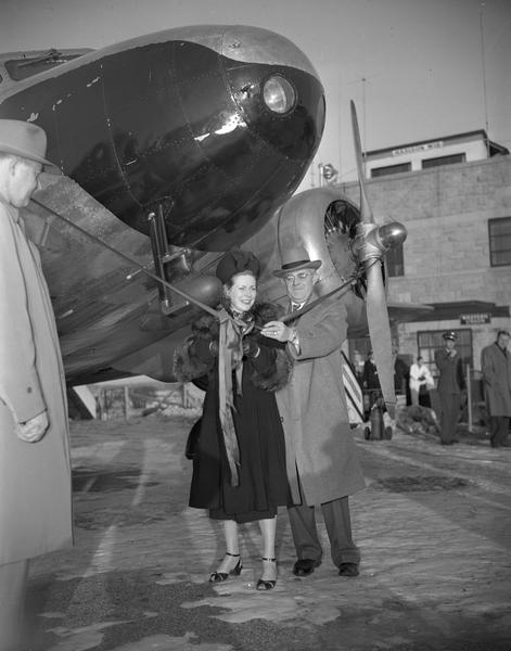 The ceremony marking the first Wisconsin Central Airlines flight at Madison. Margaret "Mickey" Morey, the wife of Howard Morey, is about to cut the ribbon. She is standing beside J.C. Higgins, president of the airlines. Wisconsin Central originated in Clintonville in 1944, but moved its headquarters to Madison in 1948 when the Air Force gave up its lease at Truax Field. Howard Morey became president of the airline after it moved to Minneapolis in 1952.