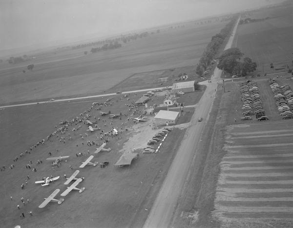 An aerial view of the air show at Tri-County Airport to celebrate the re-opening of the field under local management. Because of its location at the intersection of two mail routes, a tiny airport was established at Lone Rock.  In 1954, the Civil Aeronautics Administration relinquished control and operations were taken over by Sauk, Richland, and Iowa counties.