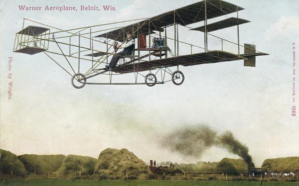 Color postcard depicting Arthur Pratt Warner of Beloit flying his Curtiss Pusher for the first time, November 4, 1909. Warner was the first person in Wisconsin to fly; he was also the first private individual in the country to purchase an airplane. The plane arrived in Beloit disassembled and not only did Warner have to put the plane together without instruction, but he also had to teach himself to fly. A historic marker near Beloit indicates where this first flight took place. (The red color of the wings is thanks to the artist's imagination.) Caption reads: "Warner Aeroplane, Beloit, Wis."