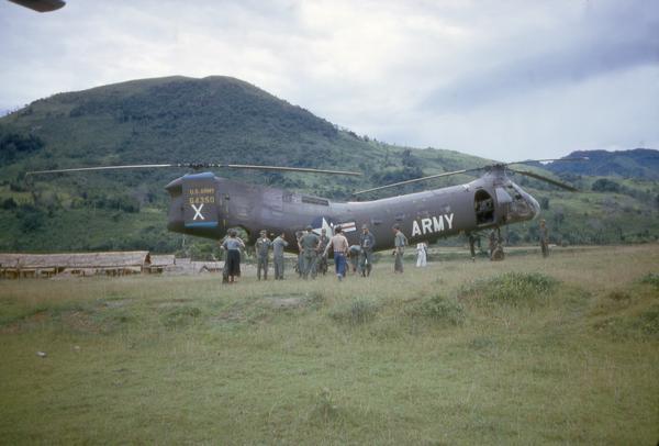 A U.S. Army Piasecki CH21-C helicopter operating at a newly cut drop zone strip near the Laotian border to resupply Vietnamese troops. Because of the two rotors and the curved body designed to ensure that the rotor blades did not hit each other, these helicopters were known as "Flying Bananas." This photograph was taken by Dickey Chapelle, a freelance photographer from Milwaukee.