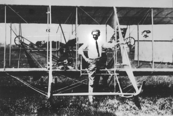 Chicago Tribune cartoonist John T. McCutcheon with his Wright Model B airplane, probably photographed at Cicero Field. McCutcheon is sometimes referred to as the "Dean of American Cartoonists." Jesse Brabazon, owner of the album from which this photograph comes, recalled McCutcheon as a "proficient pilot" and an active member of the Chicago Aero Club.