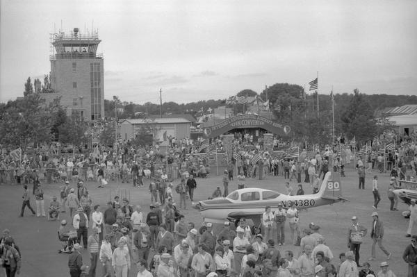 Elevated view of Experimental Aviation Association (EAA) crowds at Wittman Field in Oshkosh during the mid 1980s. The control tower is in the background.