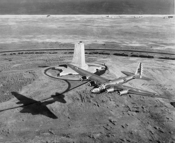Aerial view of a B-15 flying over the granite memorial to the Wright Brothers' first flight at Kitty Hawk, North Carolina. The 60-foot memorial was dedicated in 1932. This photograph is inscribed to aviation publicist Harry Bruno from the pilot, Major General Caleb V. Haynes, the winner of the 1939 Mackey Trophy for achievement in aviation. At its introduction in 1937 the B-15 was the largest U.S. Army bomber, but because it was underpowered, only one B-15 was ever built.