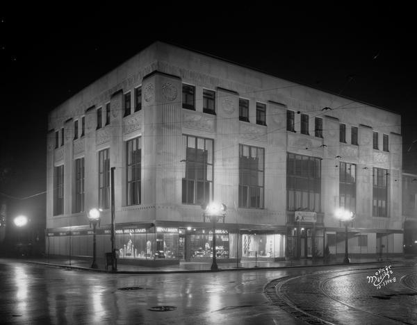 Night view of the University Avenue bank building, 905 University Avenue, designed in the Art Deco style by Weary and Alford of Chicago for the First Central Bank about 1928-1929. Rennebohm Drug Store #7 occupies the street level of the building. Notice that the streetcar tracks can be seen in the street intersection.