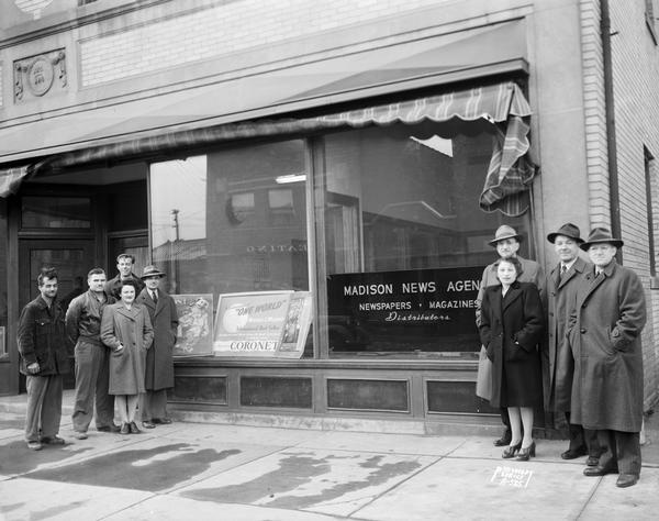 Group portrait of employees of the Madison News Agency, distributors of magazines and newspapers, in front of the business at 446 W. Gilman Street.