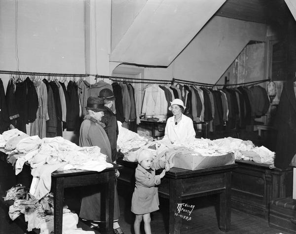 The interior of the Service Shop, second-hand store at 113 E. Doty Street, with customers looking through the merchandise.