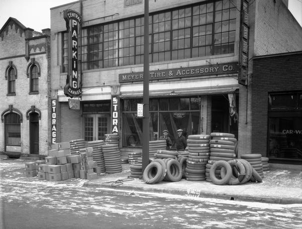 Meyers Tire & Accessory Co., 215 East Washington Avenue, with a shipment of new Federal truck tires piled on the sidewalk in the front of the building. Snow is on the ground.