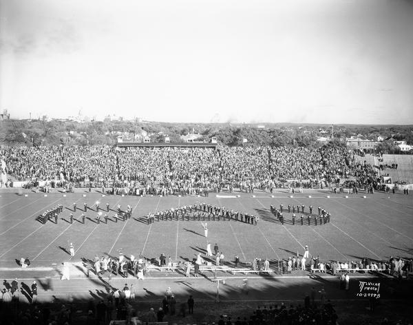 University of Wisconsin band marches in a "DAD" formation at the Wisconsin-Purdue football game. The dome of the Wisconsin State Capitol is in the background.