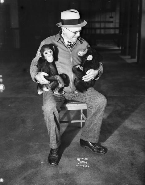Fred Winkleman holding a new pair of chimpanzees, Nip and Tuck, at Henry Vilas Zoo (Vilas Park Zoo).