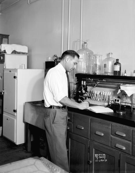 Dr. Claude Reading, new director of the state veterinary control laboratory in Agriculture Hall at the University of Wisconsin, at work in his laboratory.