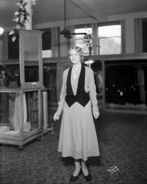 Miss America, Margaret Ekdahl, models a Shirley Lea red dress and black vest at the Burdick & Murray Department Store.
