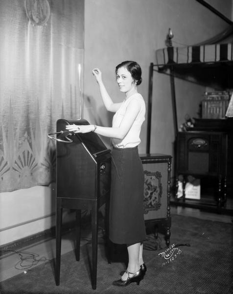 Charlotte Hilton playing the Victor Theremin musical instrument invented by Leon Theremin, at the Ludlow Radio Company store, 116 N. Fairchild Street.