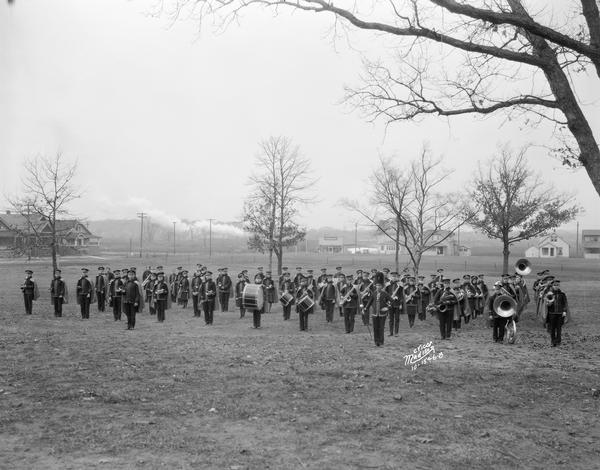 East High School marching band wearing uniforms, marching in formation in a field.