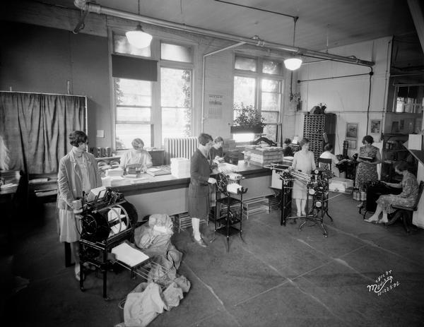 Women work at various work stations in the General Laboratories mailing and filing room, located at 124 South Dickinson Street.