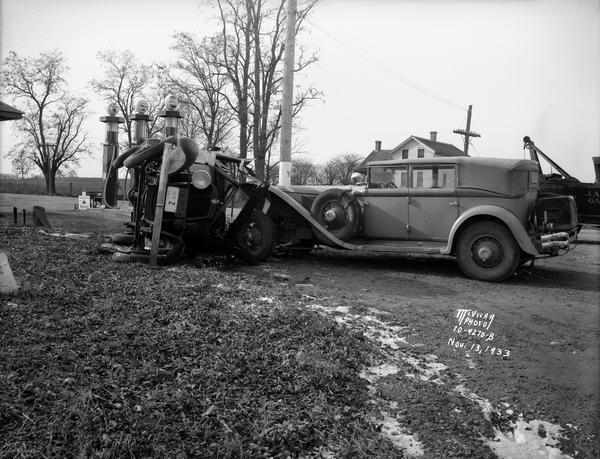 Frank Lloyd Wright's 1929 L-29 Cord Phaeton automobile and front end view of overturned Choles Floral Company truck at an accident scene at Lakeview north of Oregon, corner of Lakeview Road Highway B and Oregon Road Highway MM. The McAvoy farm house is in the background, and Adrian and son Carroll Kellor's Wadhams Mobil service station gas pumps are in the foreground.