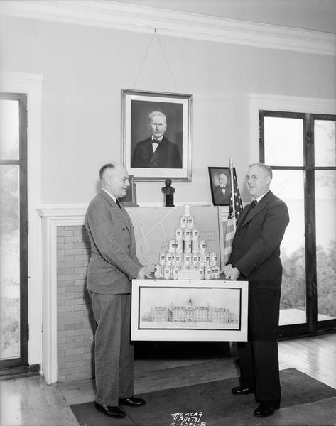 Roy Bergengren and Earl Rentfro holding display of bank cans printed with Phillips 66 labels.