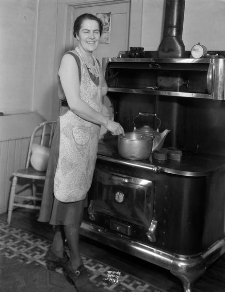 Mrs. Wilson Mutchler of Stoners' Prairie farm at 2533 Mutchler Road, south of Madison, cooking soup on a woodstove.